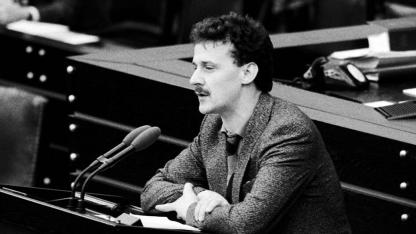 schwarz-weiß Foto: junger Mann mit Schnurrbart steht am Rednerpult